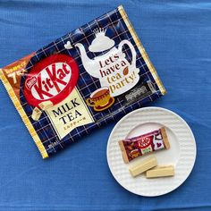 a bag of milk tea next to a plate with two pieces of cake on it