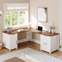 a desk with a laptop on top of it in front of a window and rug