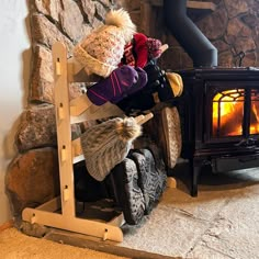 a person sitting on a bench in front of a fire place with hats and mittens