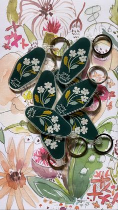 several pairs of scissors sitting on top of a flowered wallpaper covered tablecloth