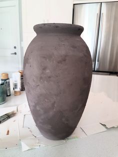 a large gray vase sitting on top of a counter