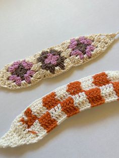 two crocheted objects sitting on top of a white table next to each other