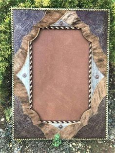 a brown and black frame sitting on top of some green grass with an animal print