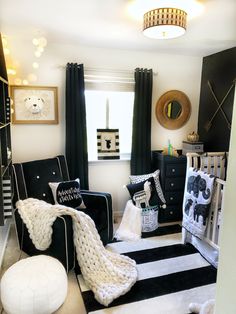 a black and white nursery room with striped rugs