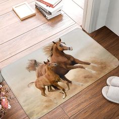 two horses running in the sand on a rug