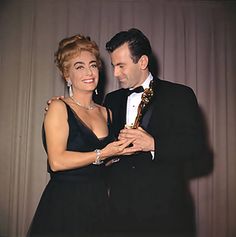 an old photo of a man and woman posing for the camera with their oscar award