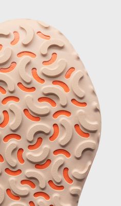 the sole of a shoe with orange and white designs