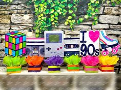 a table topped with vases filled with flowers next to a video game controller and other items