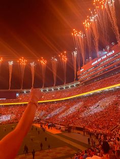 a stadium filled with lots of people watching fireworks