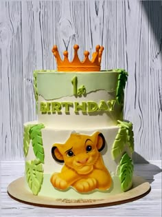 a birthday cake with a lion design on the side and a crown on top that says la birthday