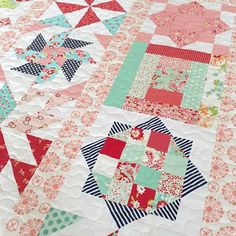 a close up of a quilt with many different designs on it, including stars and stripes