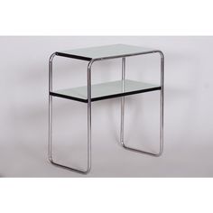 a glass and metal side table with two shelves on the bottom, one shelf is empty