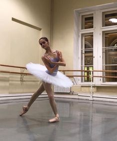 a young ballerina in a ballet studio posing for the camera