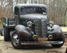 an old truck is parked in the woods