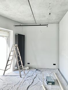 a ladder is in the middle of a room being remodeled with white walls and paint