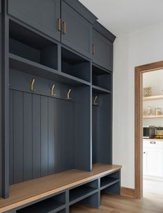 an empty room with some wooden benches and cabinets on the wall next to each other