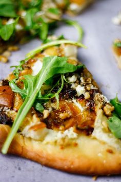 a slice of pizza with spinach and other toppings sitting on top of a table