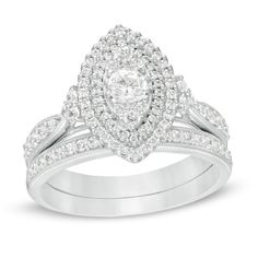 a white gold engagement ring set with an oval shaped diamond center surrounded by round brilliant cut diamonds