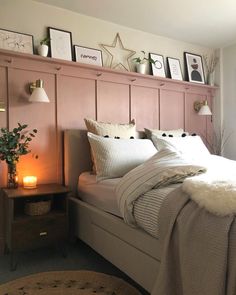 a bed with white sheets and pillows next to a wooden headboard in a bedroom