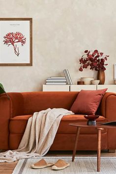 a living room with an orange couch and some books on the shelf next to it