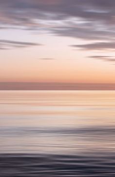 the sky is reflected in the water as it sits on top of an ocean shore