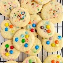 cookies with m & m candies and sprinkles on a cooling rack