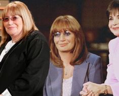 two women sitting next to each other in front of a tv screen with the same woman on it