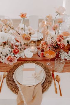 the table is set with flowers, candles and place settings for an elegant dinner party