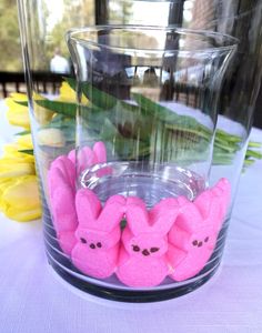 some pink peepies sitting in front of a glass vase