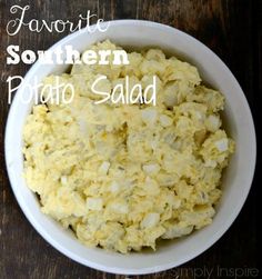 a white bowl filled with potato salad on top of a wooden table