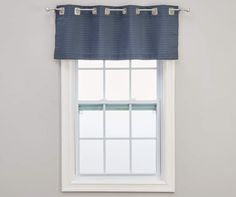 a white window with a gray curtain hanging from it's side