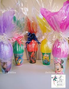 some plastic cups are lined up on a table and wrapped in cellophane with bows