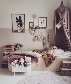 a bed room with a neatly made bed next to two pictures on the wall and stuffed animals