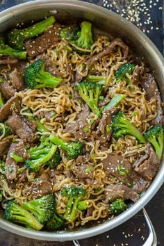 beef and broccoli stir - fry in a skillet with sesame seed noodles