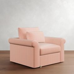 a pink chair sitting on top of a hard wood floor next to a white wall