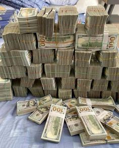 stacks of money sitting on top of a bed