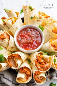 a platter filled with tortillas and salsa