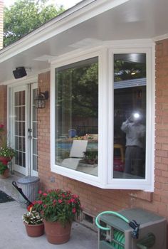 a man is taking a photo in the window of his house while he takes pictures