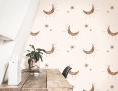 the wallpaper is decorated with stars and crescents on it, along with a potted plant