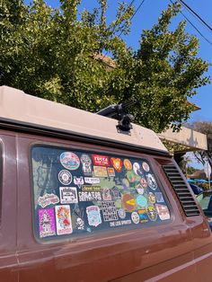 an old van with stickers on the side and trees in the backgroud