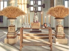 the altar is decorated with candles and flowers in front of two statues on pedestals