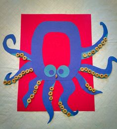 an octopus made out of construction paper on top of a sheet of red and blue paper