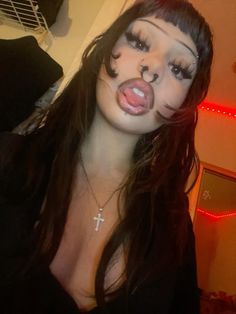 a woman with her face painted to look like a cat and cross on it's nose