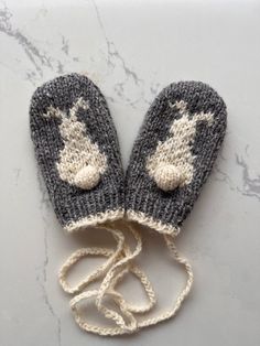 These cute hand knit baby mittens are made of all natural, super soft yarn that is absolutely non itching. The main colour of the mittens is medium grey combined with white, medium grey for the bunny. The mittens are conveniently attached by a 80 cm long cord that prevents them from getting lost. The natural yarn used consists of 50% merino wool, 25% alpaca and 25% viscose and is produced by Drops in Norway. The mittens can be washed by hand or in the machine by selecting the 'hand wash' or 'del Knit Baby Mittens, Baby Mittens Knitting Pattern, Baby Mittens Knitting, Toddler Mittens, Kids Mittens, Knitting Hacks, Crochet Baby Sweater, Tweed Yarn, Baby Mittens