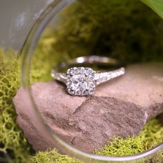 a close up of a ring on top of a rock with moss growing around it