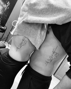 two people with matching tattoos on their stomachs, one has the word love written in cursive writing