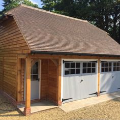 a small wooden garage with two doors on the front and one door open to let in light