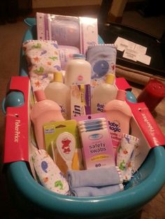 a blue basket filled with baby items on top of a table