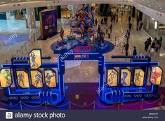 the entrance to an indoor shopping mall at night time with people walking around and onlookers