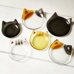 four cat shaped dishes sitting on top of a white table